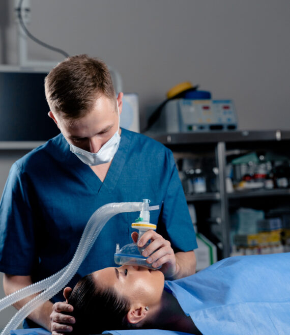 Anesthesiologist making ingalation anesthesia for patient. Doctor puts a mask on the patient before starting operation
